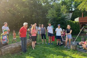 mehrere Menschen stehen zur Begrüßung auf dem Gelände des Kletterparks