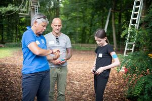 Ein Kind mit Diabetes im Dialog mit den Betreuern im Hochseilgarten.