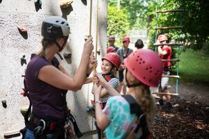 Kinder mit Diabetes bei der Einweisung an der Kletterwand im Hochseilgarten.